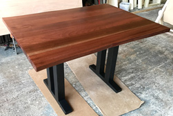 Bandera Table - Mahogany table with optional live edge cut and custom black trestle base for banquette seating