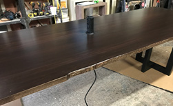 Richardson Table - Large bronze walnut table with live edge cut and grommet for a conference room