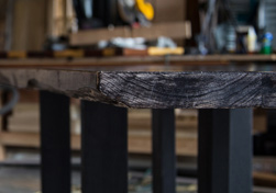 Charleston Table - Subtle live edge on a rustic black finish table top with grey nail holes and line textures