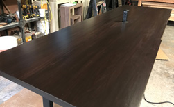 Richardson Table - Large bronze walnut conference table with live edge cut and grommet